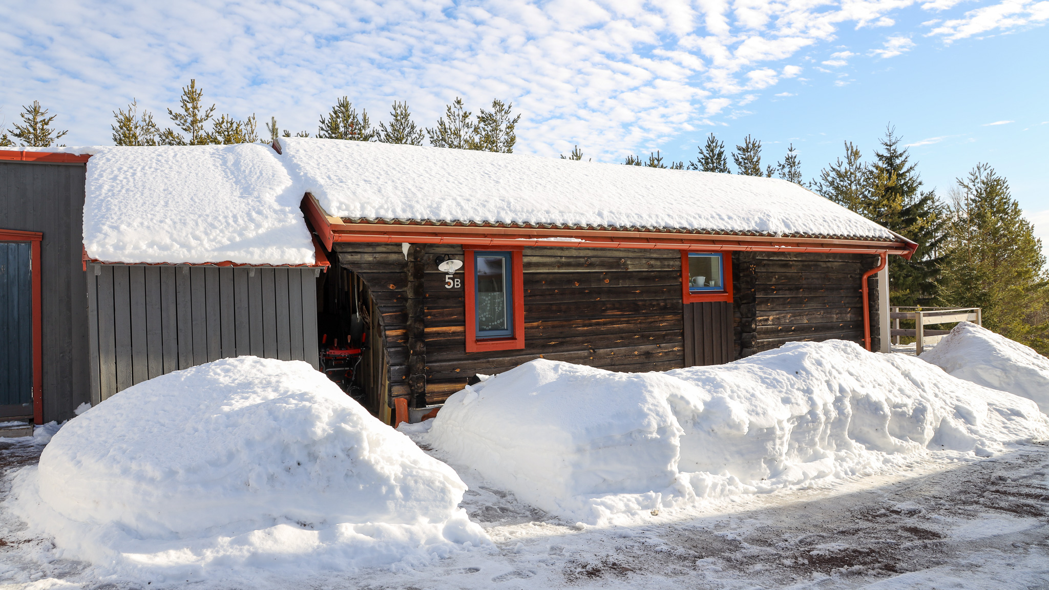 Byggnad med röda dörrar och snöhögar framför i vintermiljö. Byggnad med röda dörrar och snöhögar framför i vintermiljö.