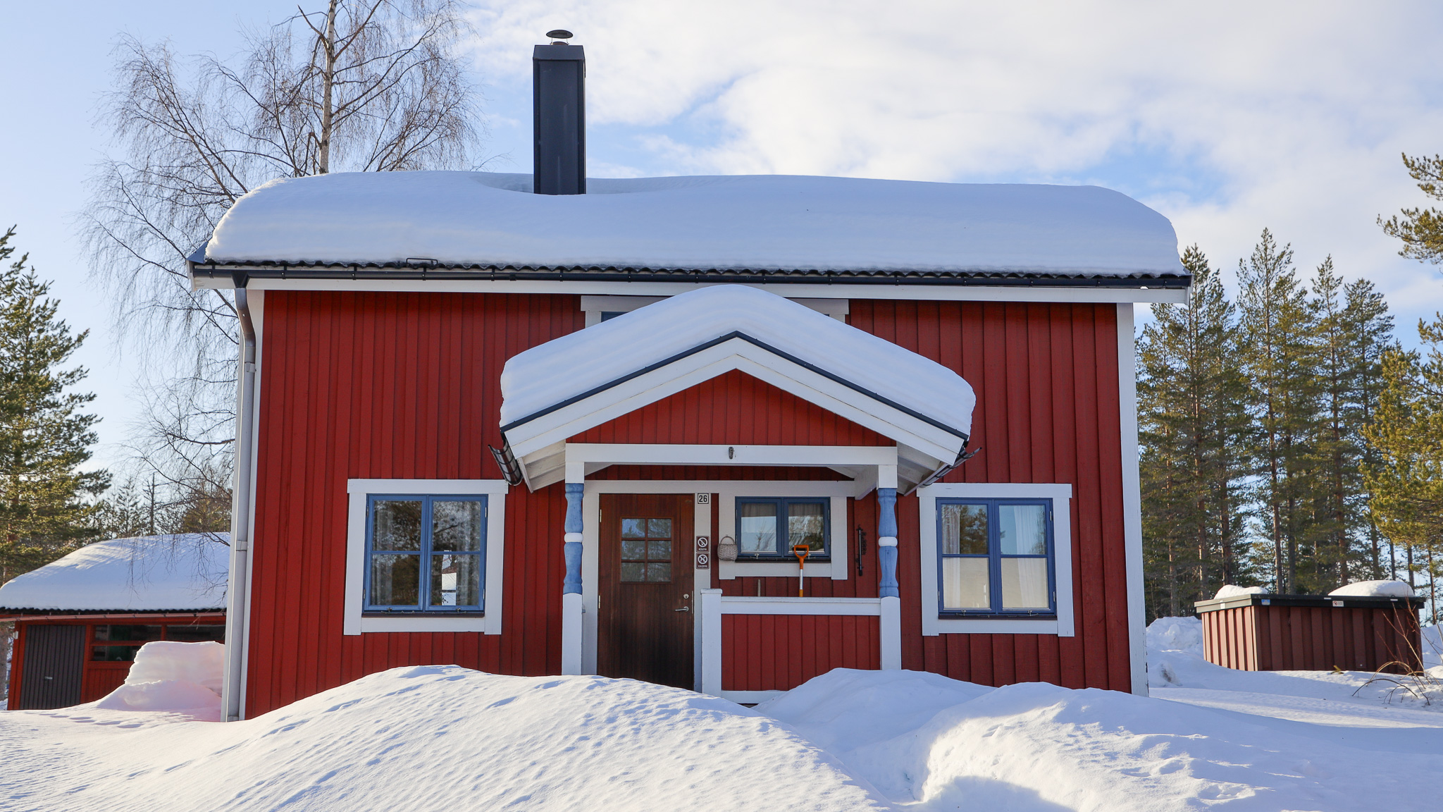 Röd byggnad med vit entré och snö på marken. Röd byggnad med vit entré och snö på marken.