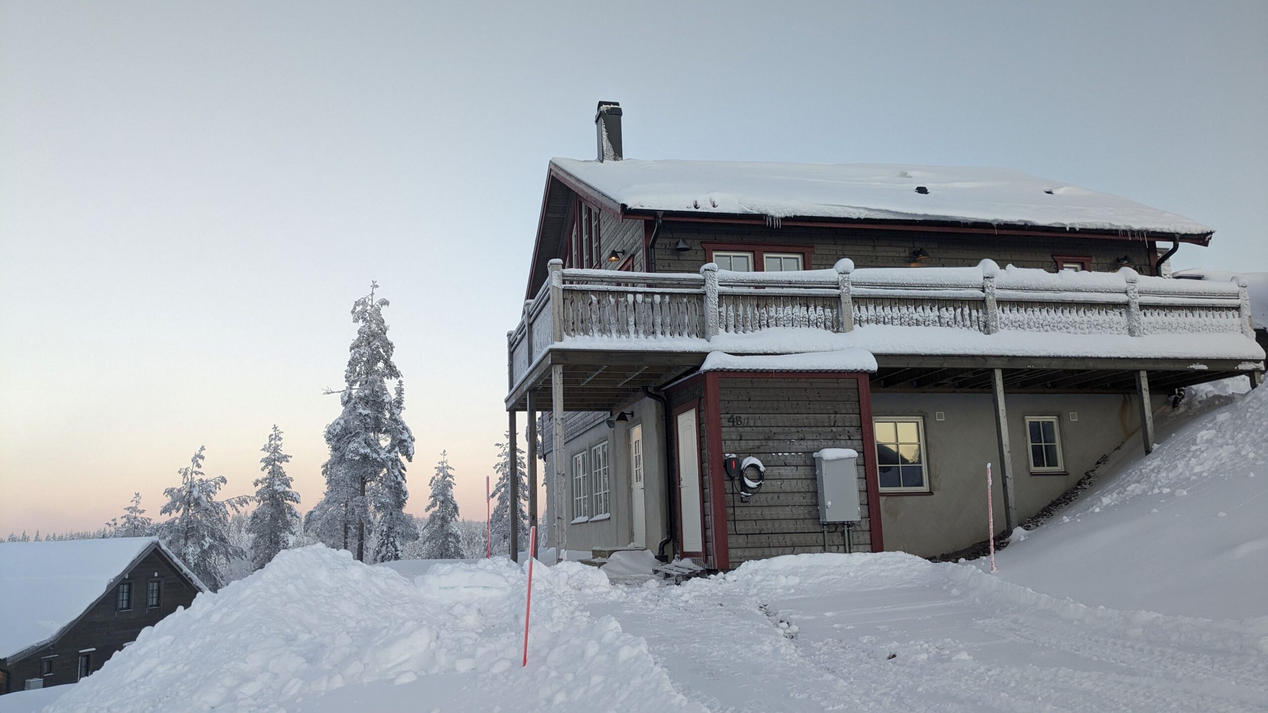 Byggnad med snötäckt tak och balkong i vintermiljö. Byggnad med snötäckt tak och balkong i vintermiljö.