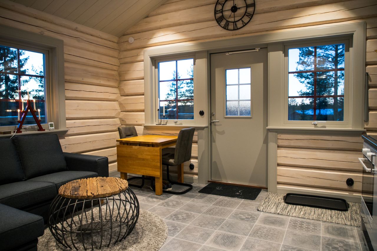 Hall med ytterdörr, sittbänk, förvaring och fönster med färgade glasdetaljer.