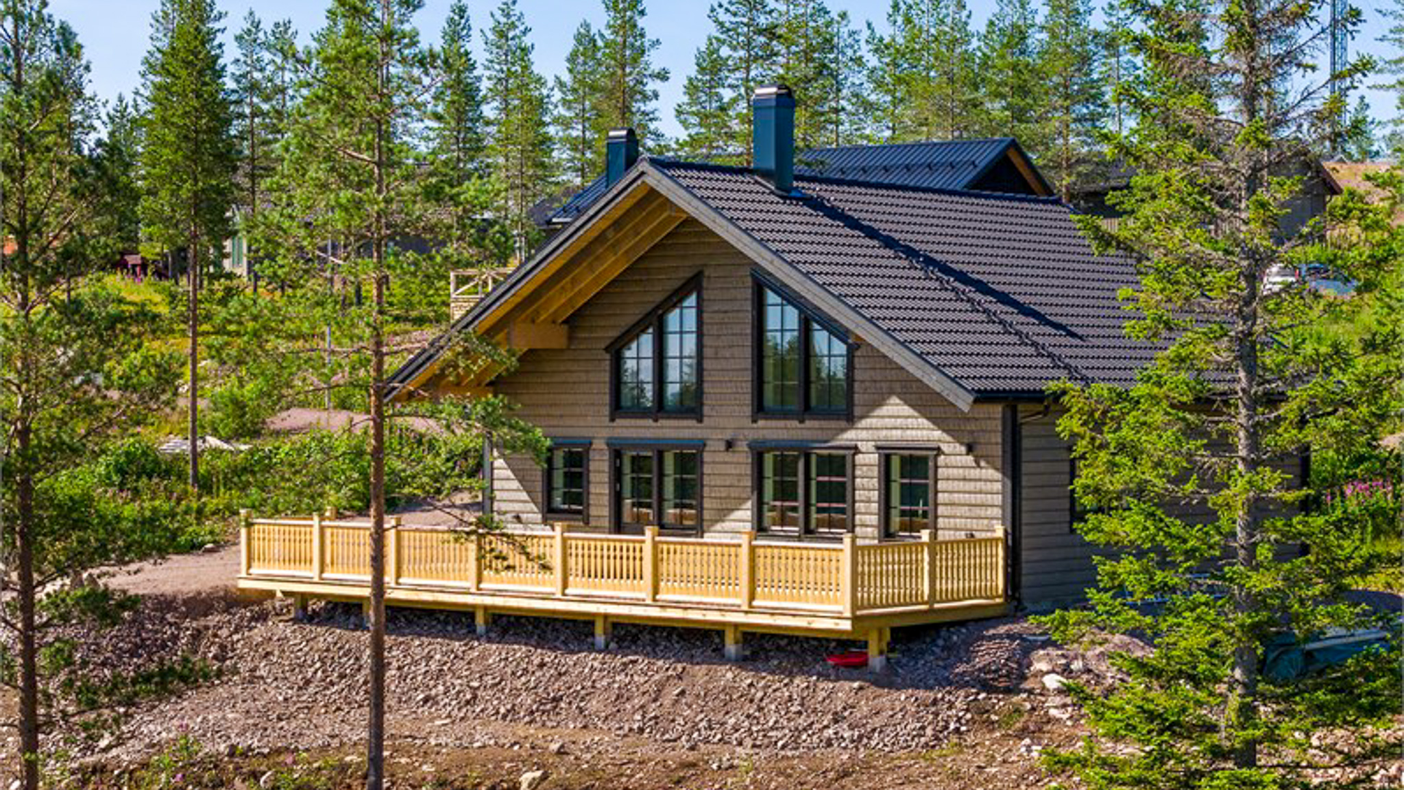 Trästuga med veranda och omgivande skog i sommargrön miljö. Trästuga med veranda och omgivande skog i sommargrön miljö.